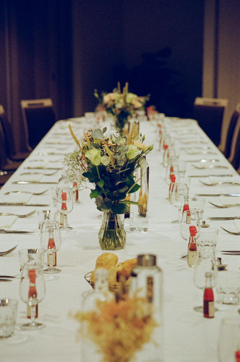 Table de réception élégante avec bouquet de fleurs et couverts, décorée pour un événement festif.